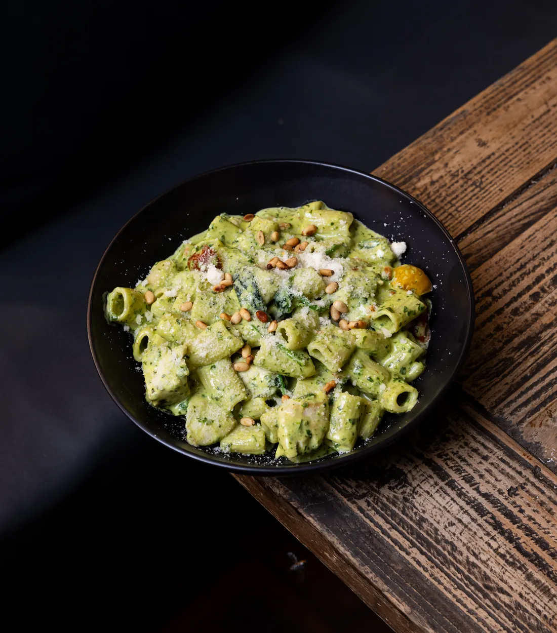 A bowl of pesto rigatoni with toasted pine nuts